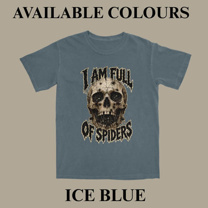 An ice blue t-shirt with a distressed graphic of a skull and the text 'I AM FULL OF SPIDERS' on a solid beige background, with text overlays reading 'AVAILABLE COLOURS' at the top and 'ICE BLUE' at the bottom.