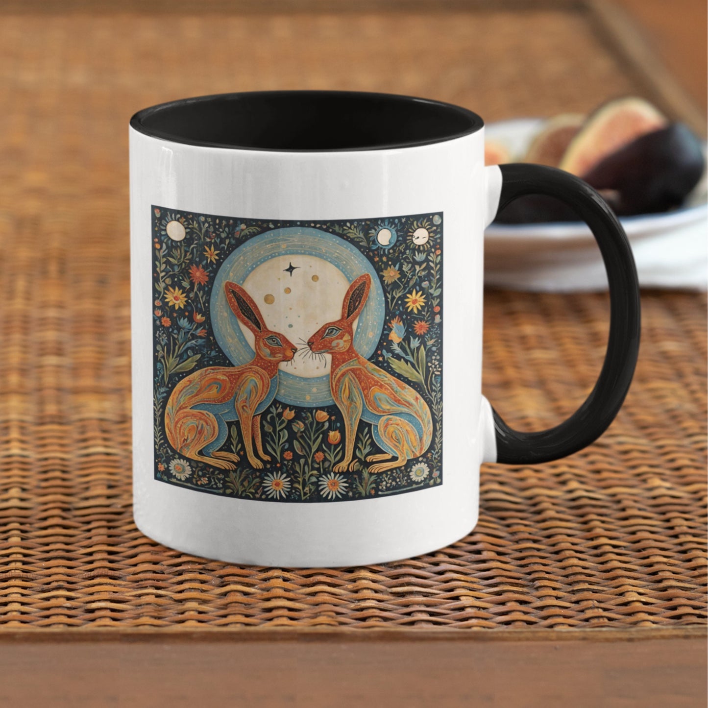 11 oz ceramic mug with a black interior and handle, featuring a folk art moon gazing hares facing each other under a radiant full moon, symbolizing the mystical power and influence of the moon. Yoga, manifesting gift. Mindset gift, Law of Attraction.