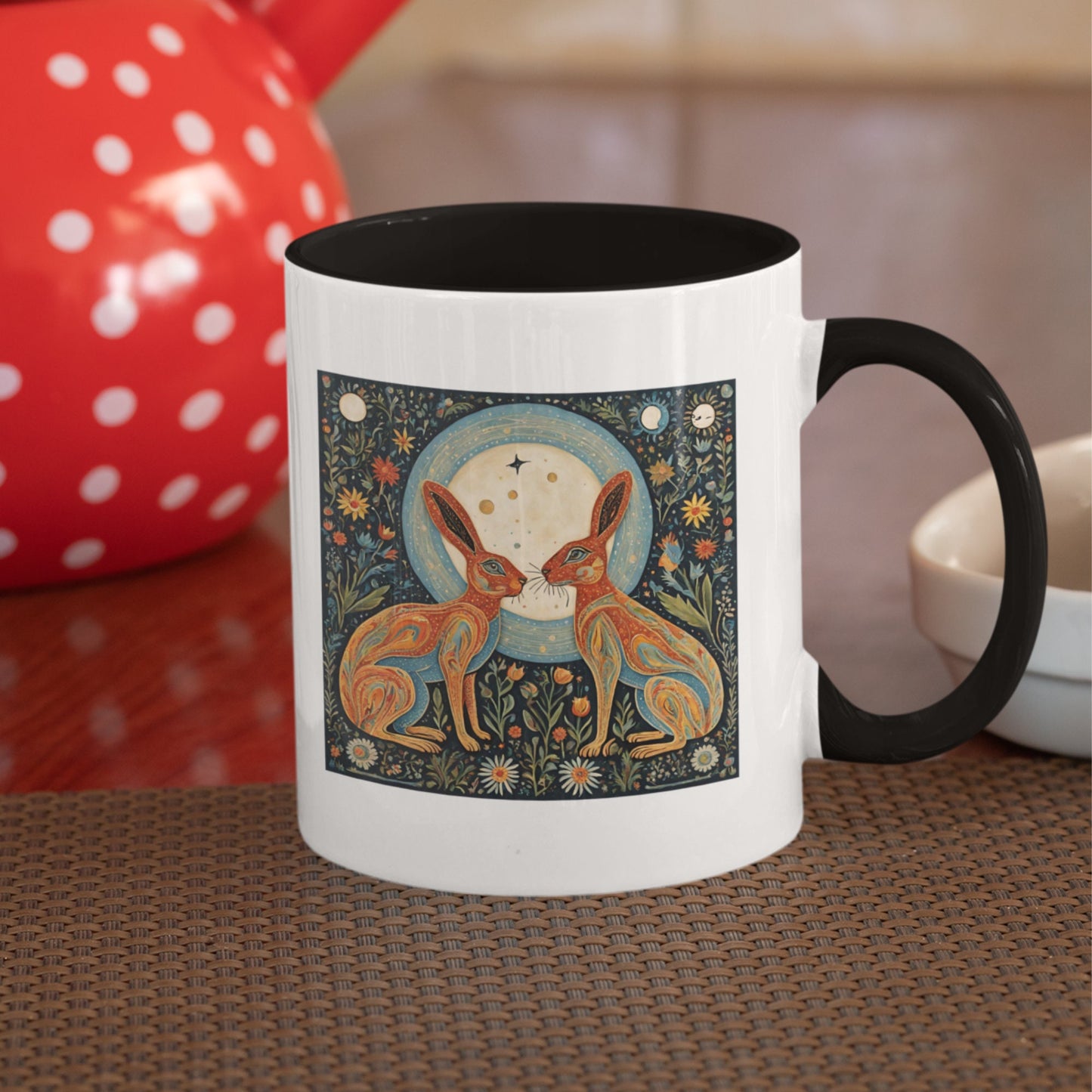 Stylish black-handled mug showcasing a nature-inspired illustration of two magical hares amidst flowers and lunar phases
