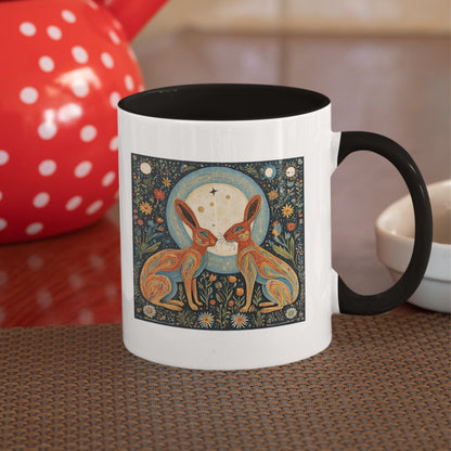 Stylish black-handled mug showcasing a nature-inspired illustration of two magical hares amidst flowers and lunar phases