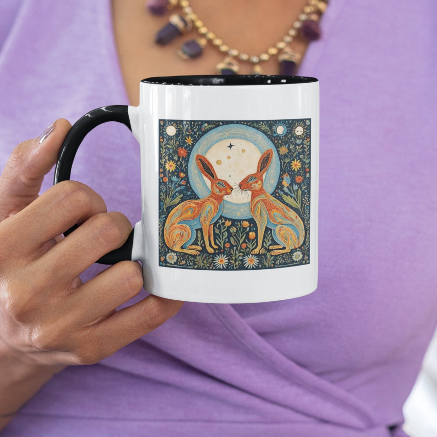 Artistic mug with a striking illustration of two hares framed by a glowing moon, surrounded by wildflowers and stars