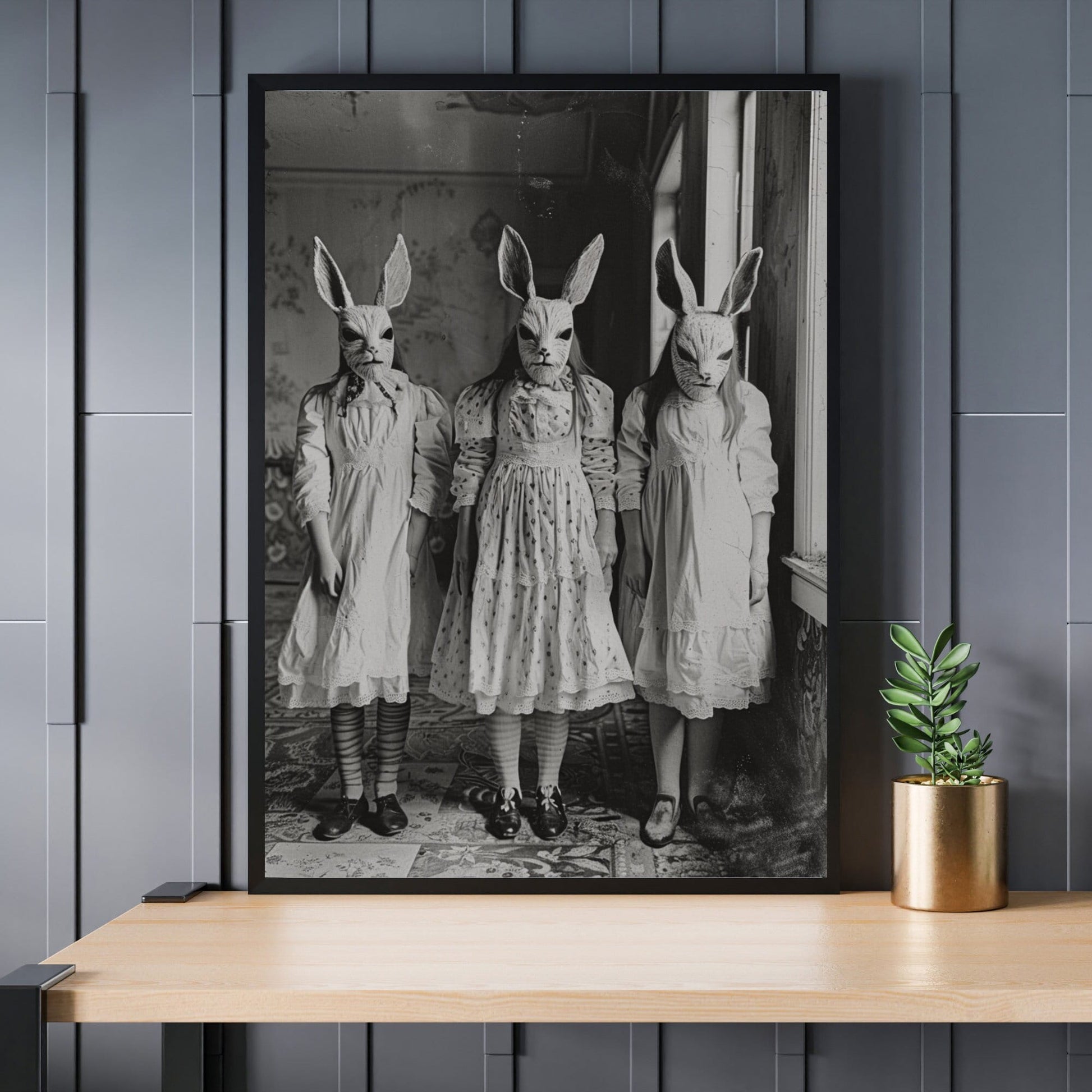 Black and white vintage photograph of three children wearing rabbit masks and Victorian dresses, standing in a dimly lit room.