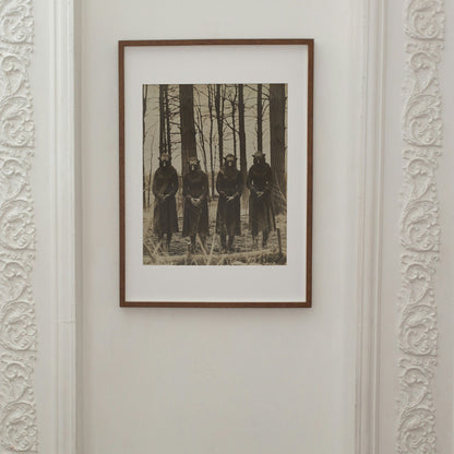 A chilling photograph of four robed figures with animal masks in a barren forest, reminiscent of an ancient ritual.