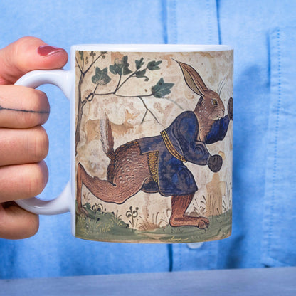 This collectible mug presents mad March hares with boxing gloves in a C9th primitive art style. The seamless design, inspired by illuminated manuscripts, wraps around the entire mug, making it a must-have for art and fantasy lovers.
