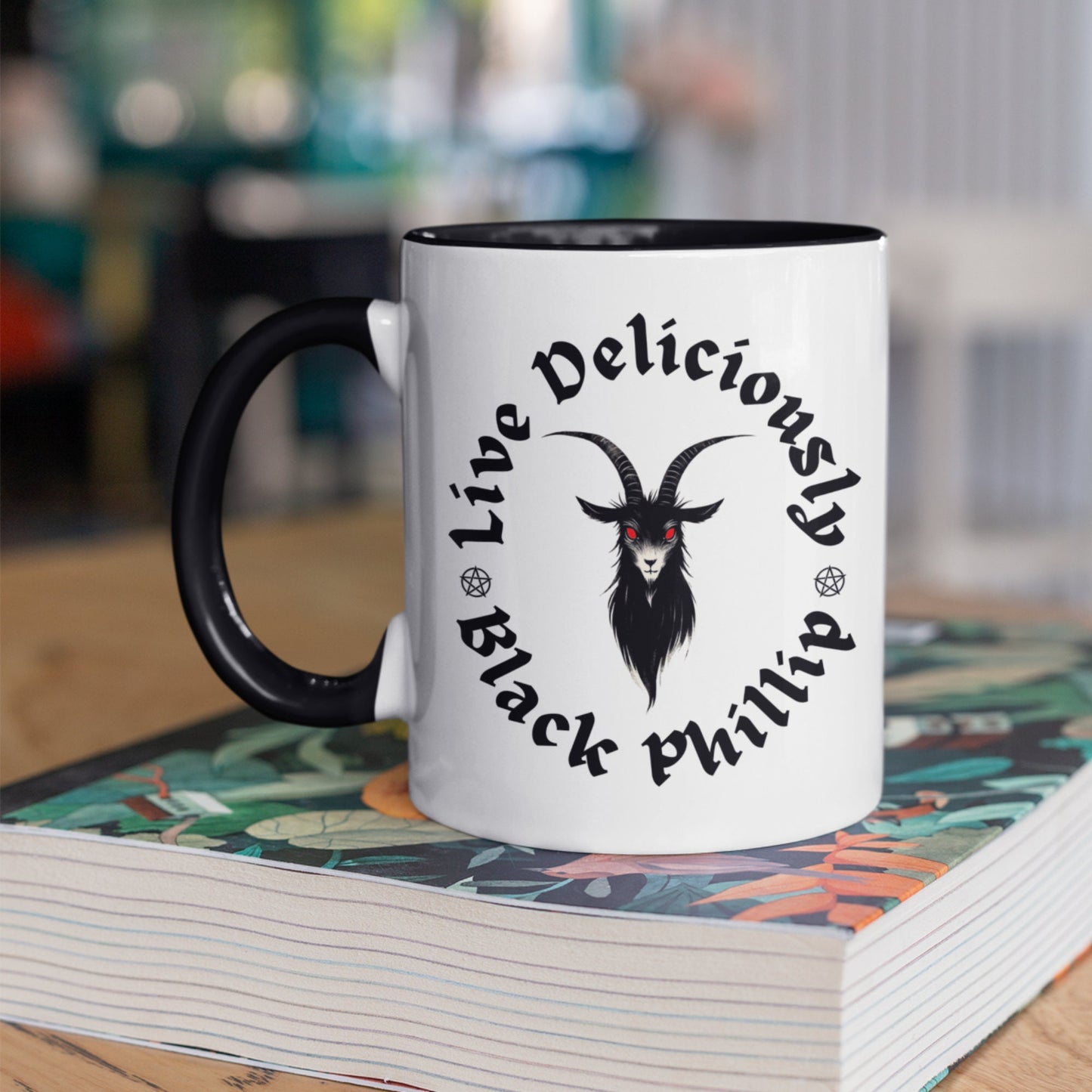 Close-up of a ceramic mug featuring a Gothic Black Phillip design with red eyes and dark text. Goat lover gift