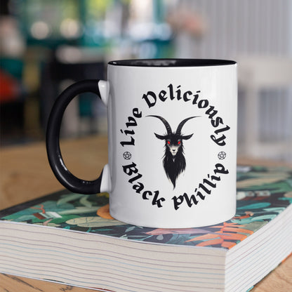 Close-up of a ceramic mug featuring a Gothic Black Phillip design with red eyes and dark text. Goat lover gift