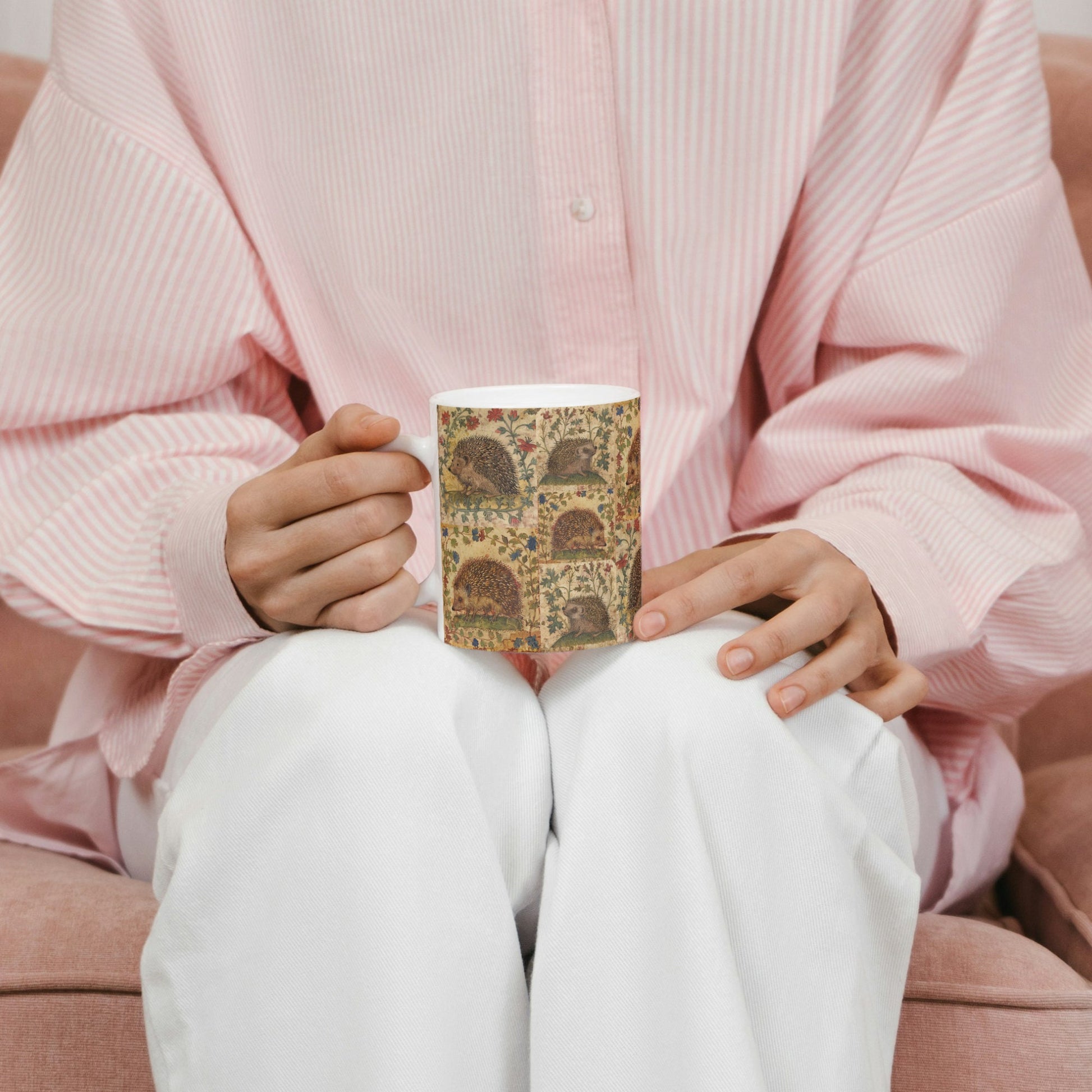 A medieval manuscript-style mug adorned with hedgehogs and plants,