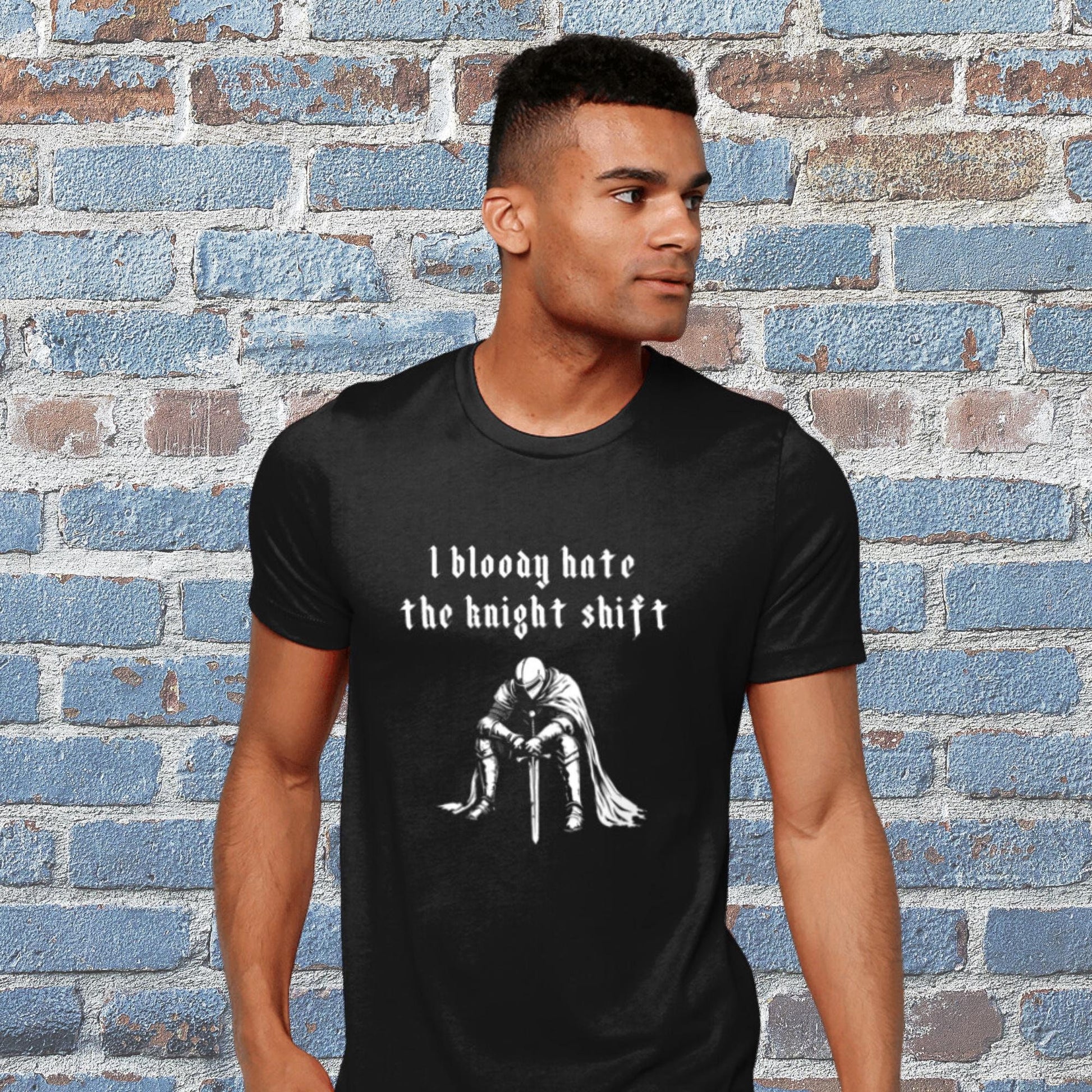 Black t-shirt with detailed illustration of a fed-up medieval knight with the humorous text &#39;I bloody hate the knight shift.&#39; Perfect for night shift workers, medieval history fans, and those with a gothic sense of humour. Marginalia Gift, Gothic Tee