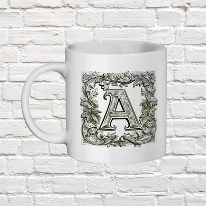 white 11oz ceramic mug with your chosen Personalised Alphabet letter. The black and white letters are in a Medieval illuminated manuscript style font surrounded by a thick border of scrolled leaves