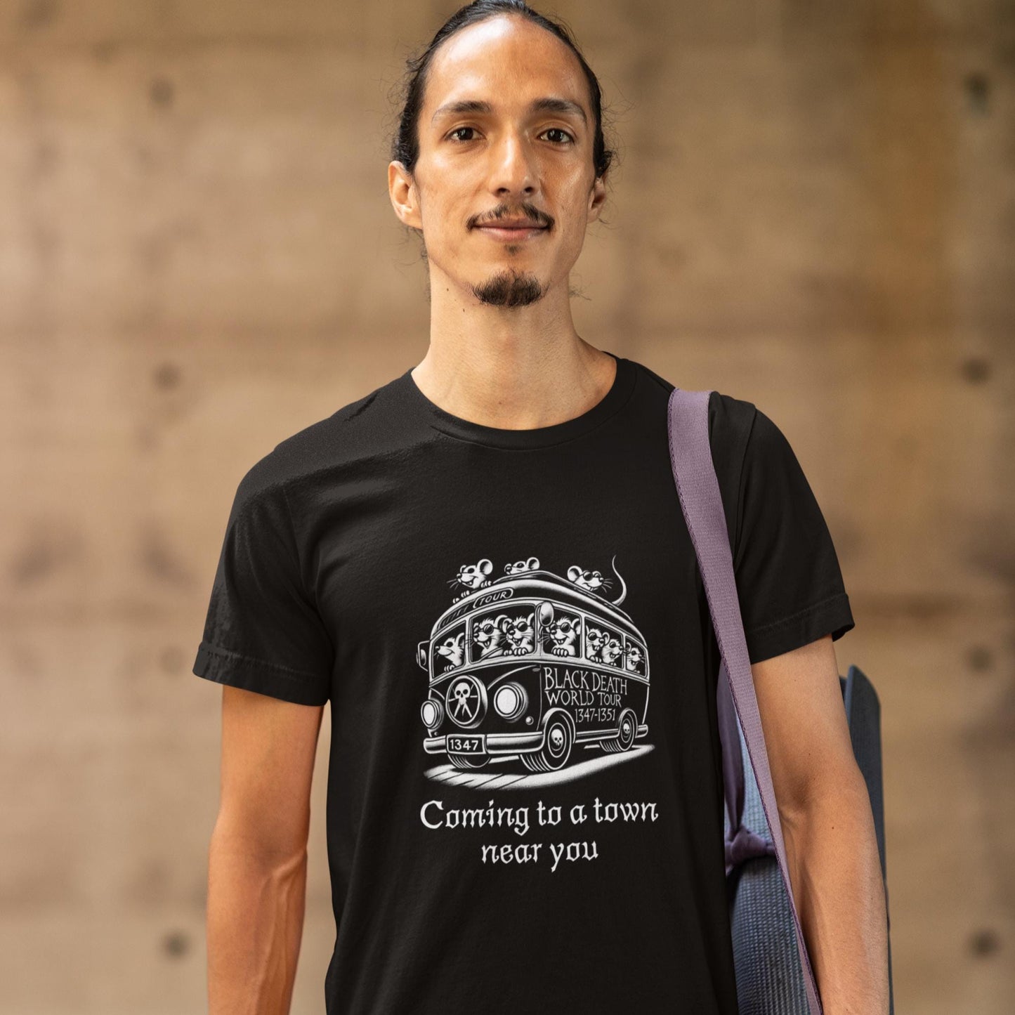 Black t-shirt showcasing a cartoon bus packed with rats, labelled &#39;Black Death World Tour 1347-1351,&#39; with the tagline &#39;Coming to a town near you