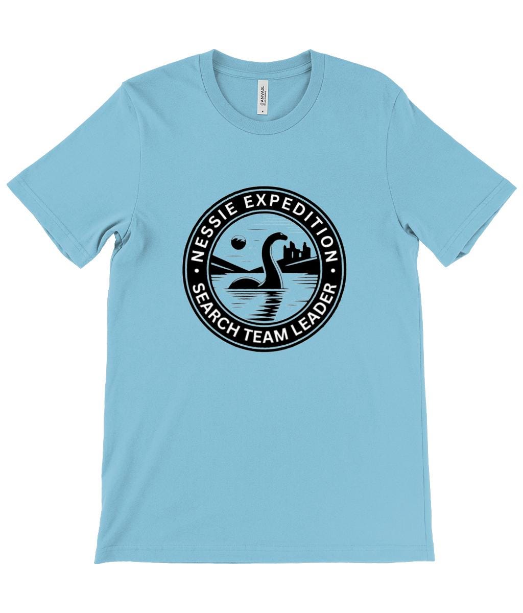 Urquhart Castle and Nessie T-Shirt - A detailed graphic showing the Loch Ness Monster with Scotland&#39;s historic Urquhart Castle in the background, ideal for those who love Scottish myths and history.