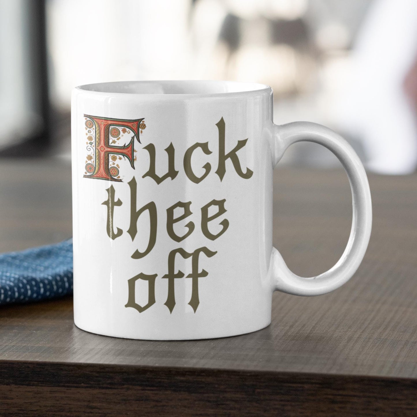 Bold 11oz mug with medieval script reading &#39;F*** Thee Off,&#39; a humorous choice for co-workers or sarcastic gifts